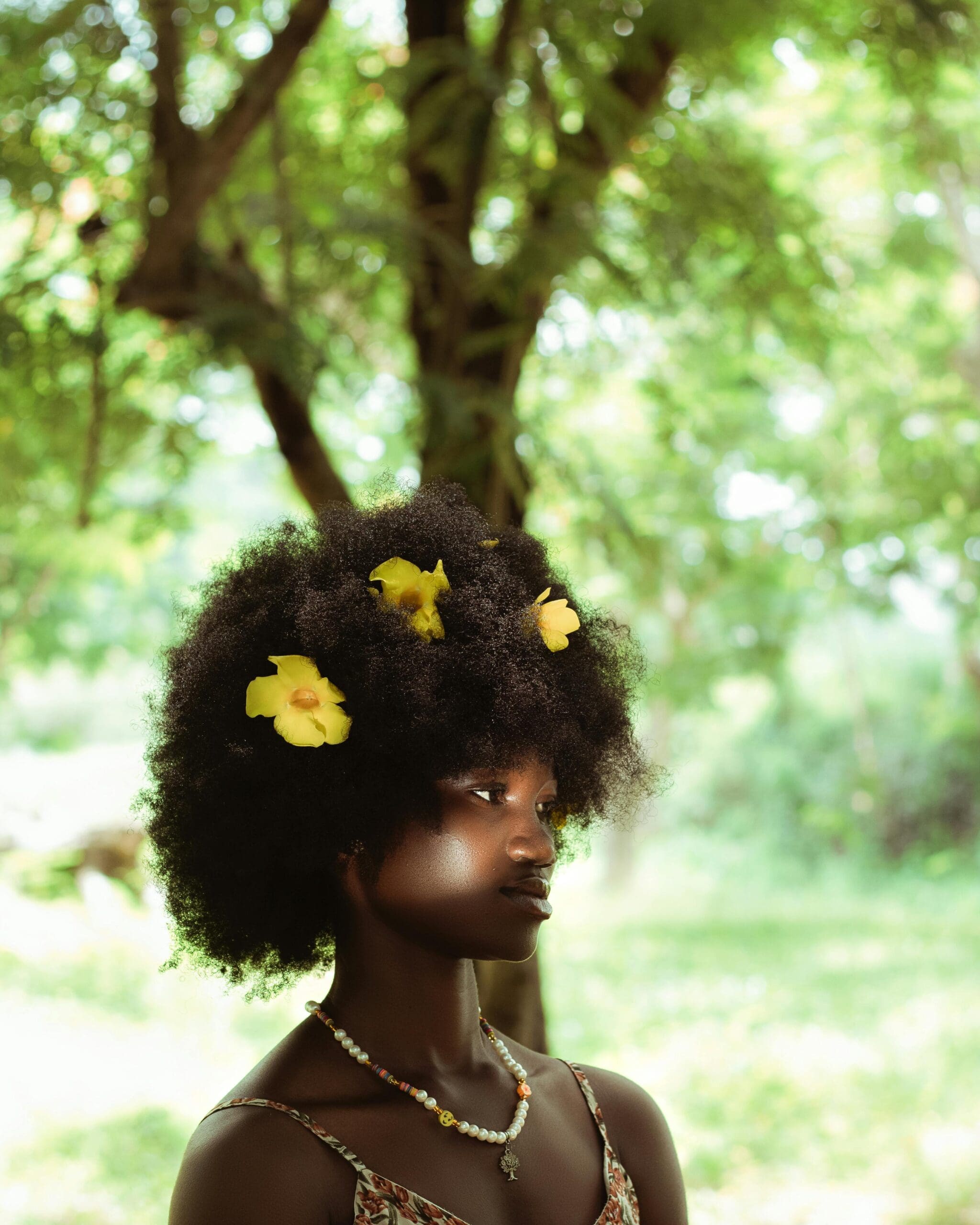 Vrouw met donkere huid buiten in daglicht, verwijzend naar vitamine D aanmaak en risico op tekort.